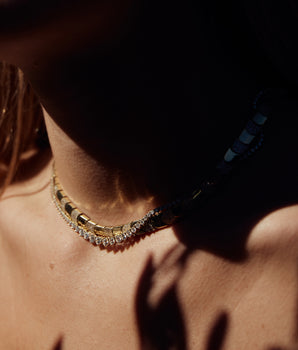Minimalist chevron necklace layered on model